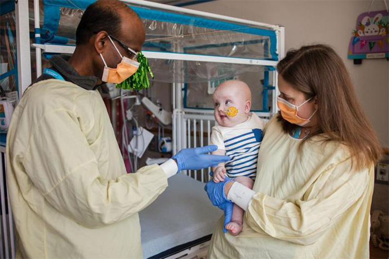Doctors with the infant patient who received personalized gene therapy for rare life-threatening genetic disorder.